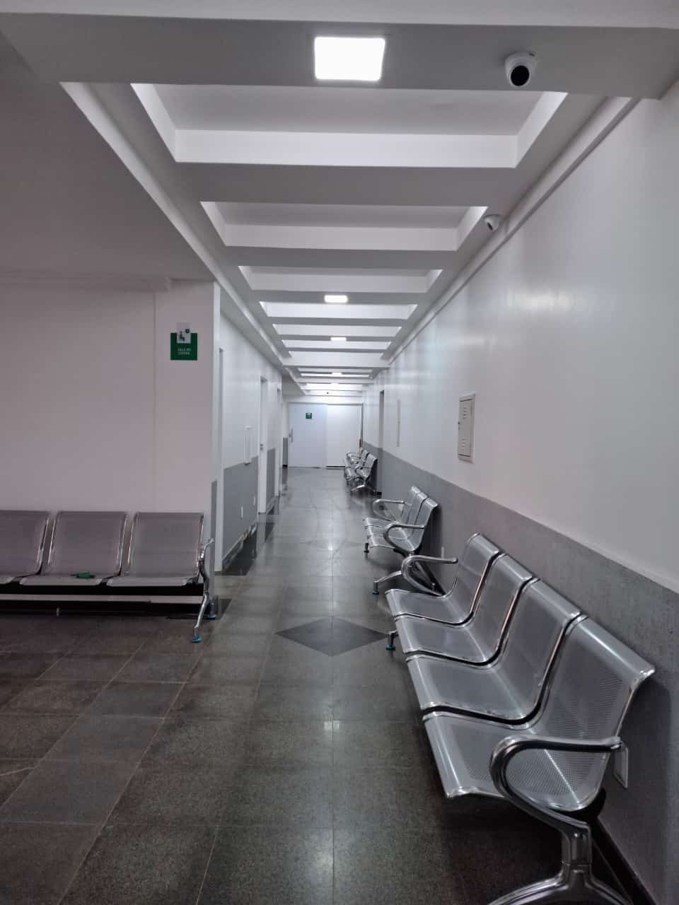 Corredor dos consultórios do Centro Médico Nexo, com cadeiras ao longo da parede