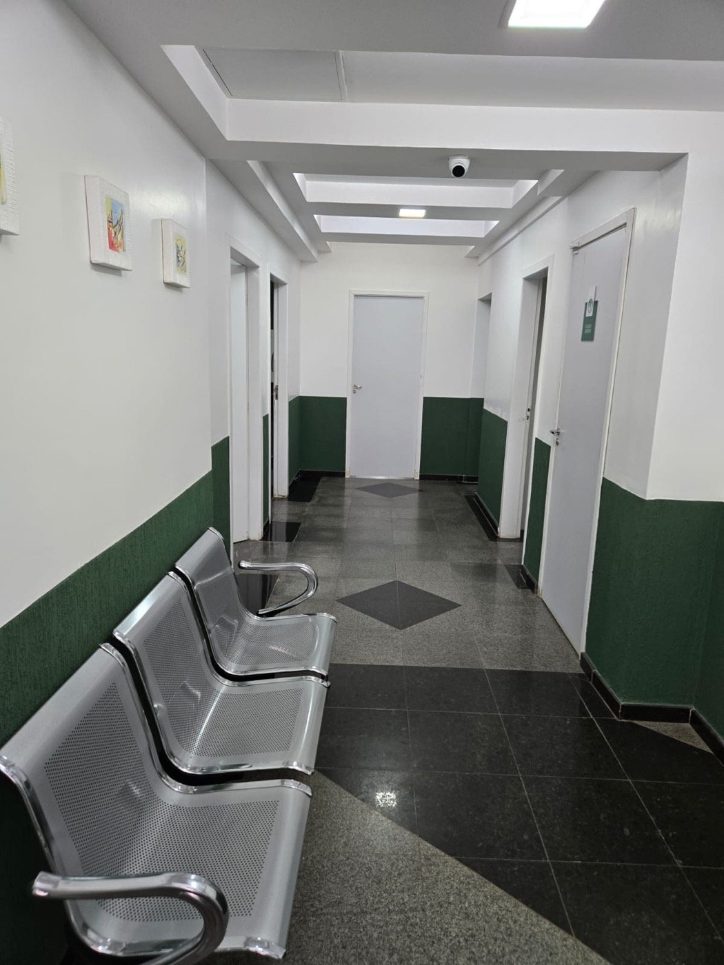 Corredor do Centro Médico Nexo, com quadros na parede