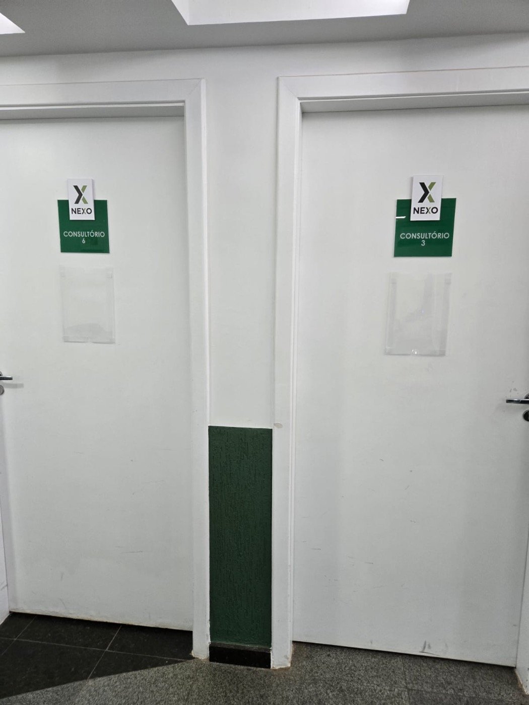 Portas de dois consultórios do Centro Médico Nexo, com as placas de número
