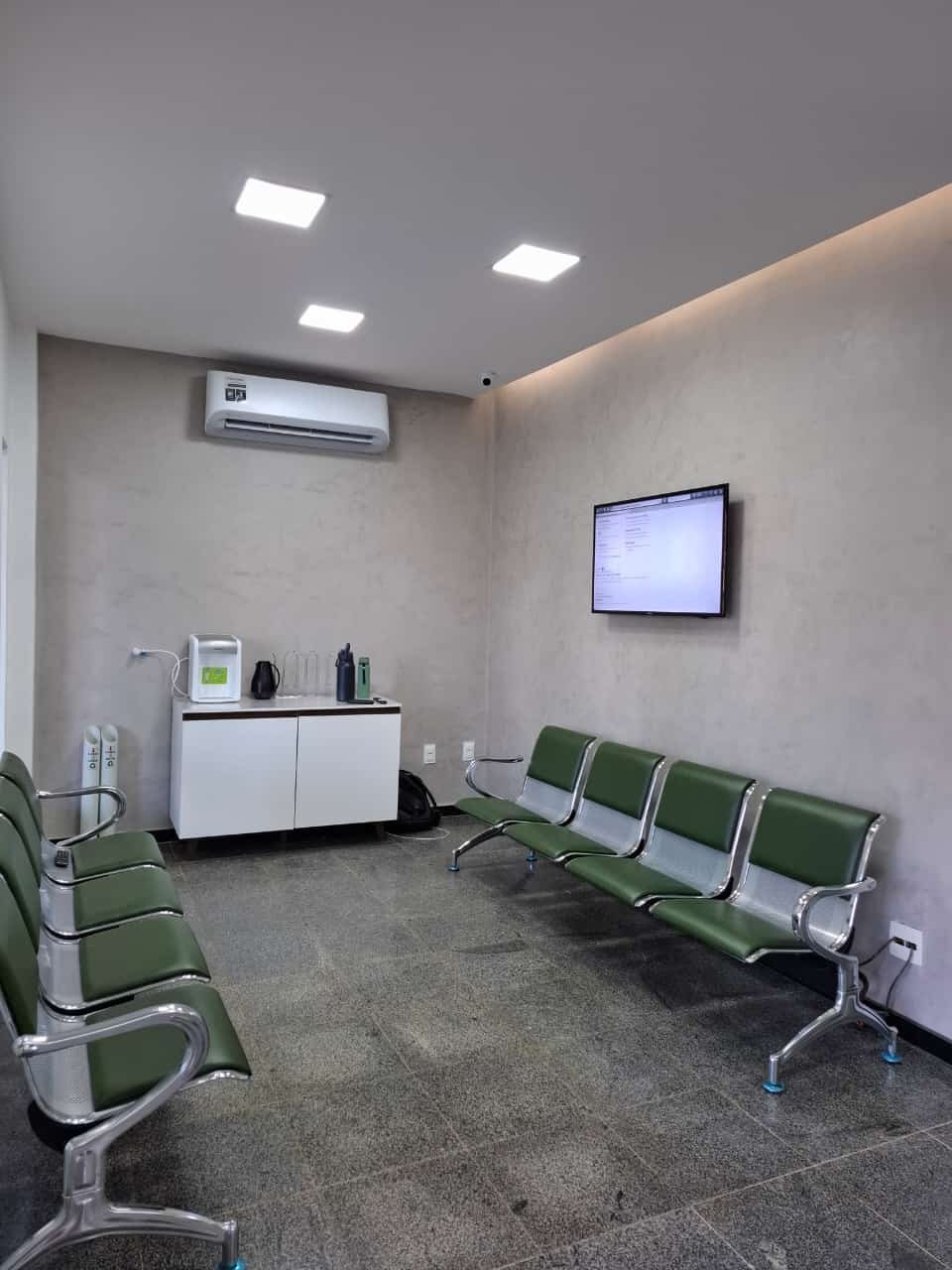 Espera do Centro Médico Nexo, com painel de chamada e ar-condicionado