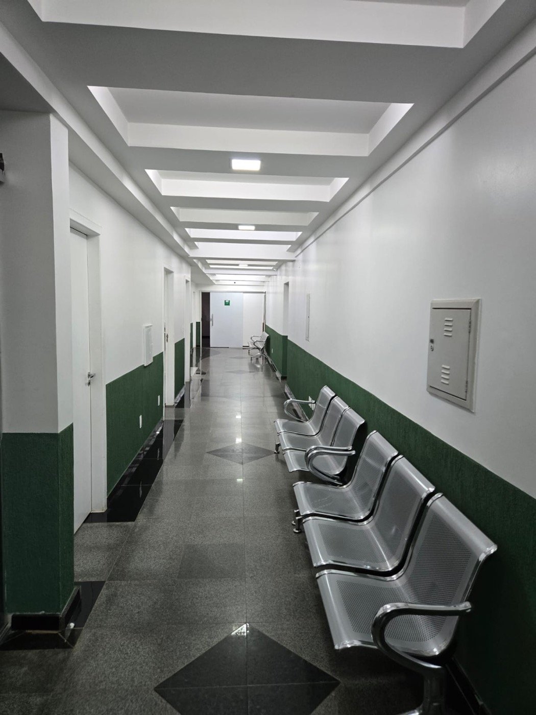 Corredor de espera do Centro Médico Nexo, com cadeiras ao longo da parede
