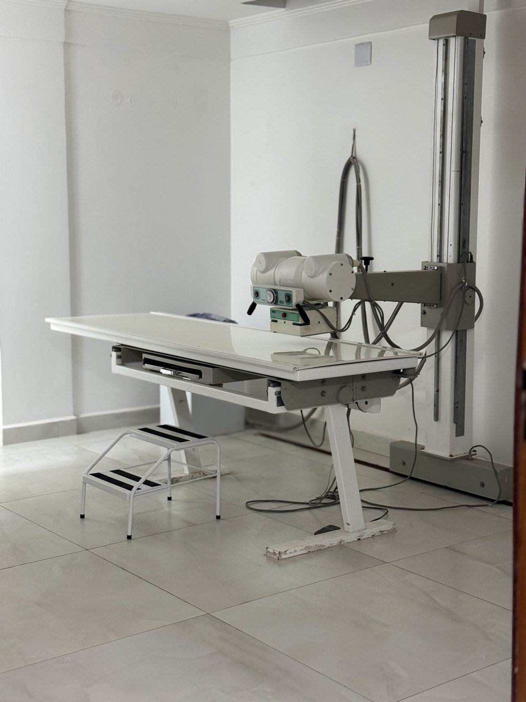 Sala de raio-x do Centro Médico NEXO, com a mesa de exame e o aparelho